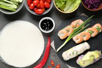 Rice paper sheets and different ingredients on dark grey table, flat lay