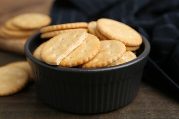 Tasty salty crackers on wooden table, closeup
