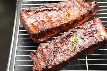 Delicious roasted pork ribs with rosemary on grill, closeup