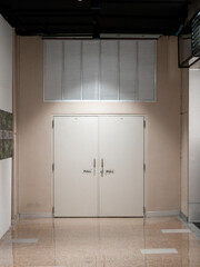 closed double emergency exit door in indoor commercial building hallway