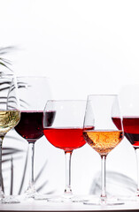 Non-alcoholic, alcohol free wine set. Red, white, rose wines in glasses. White background, shadows, hard light