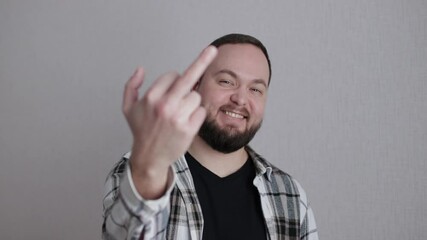 Man smiling and showing middle finger gesture on white background