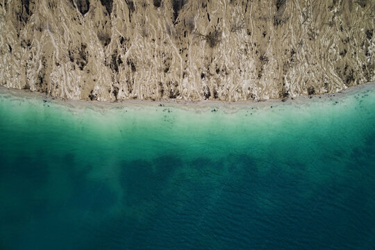 Aerial view of texture sand and emerald lake in a quarry. Line of water and land