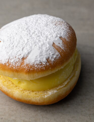 Indulge in a Delicious Creamfilled Donut generously topped with Powdered Sugar goodness