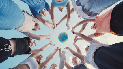 School friends reaching for a globe against a blue sky, representing global unity, environmental awareness, and international collaboration