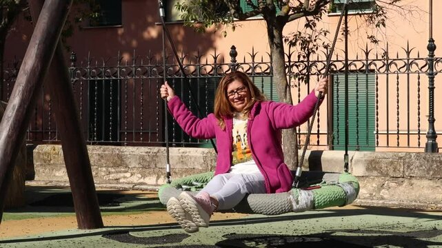 Mujer madura juega en el parque infantil