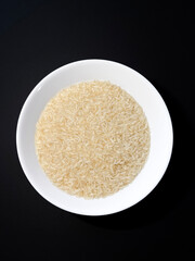Dish of rice on dark background.