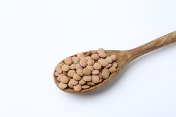 Raw lentils in wooden spoon isolated on white