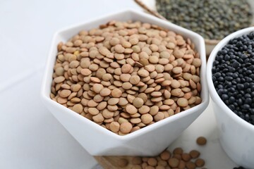 Different types of lentils on white table, closeup