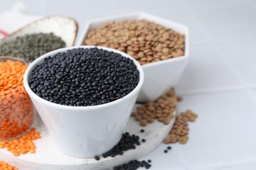 Different types of lentils on white table, closeup