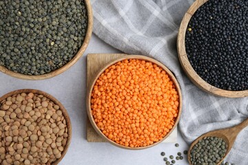 Different types of lentils on light table, flat lay