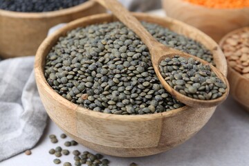 Different types of lentils on light table, closeup