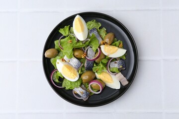 Delicious salad with herring, egg, mustard and vegetables on white tiled table, top view