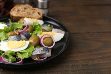 Delicious salad with herring, egg, mustard and vegetables on wooden table, closeup. Space for text