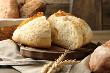 Cut freshly baked bread, spikes and knife on table, closeup