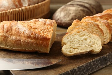 Different types of fresh bread on wooden table, closeup