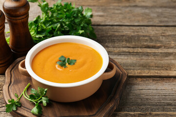 Delicious lentil cream soup with parsley on wooden table. Space for text