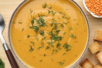 Delicious lentil cream soup with dill on wooden table, top view