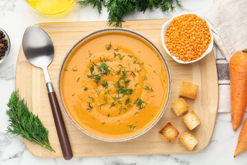 Delicious lentil cream soup with dill and ingredients on white marble table, flat lay
