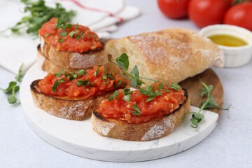 Tasty bread with tomatoes, parsley and oil on light table, closeup