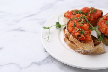Tasty bread with tomato and parsley on white marble table, closeup. Space for text