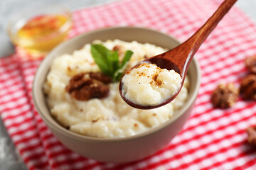 Taking delicious rice pudding at table, closeup. Space for text