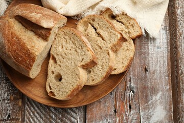 Pieces of fresh bread on wooden table, top view