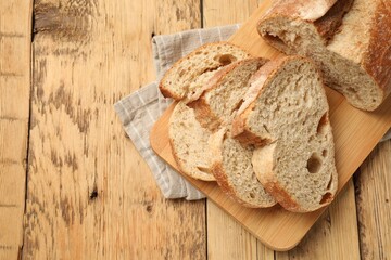 Pieces of fresh bread on wooden table, top view. Space for text