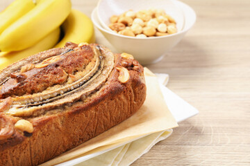 Delicious homemade banana bread with nuts and fruits on wooden table, closeup. Space for text