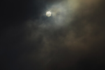Solar eclipse, sun shining through dark clouds