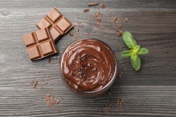 Delicious pudding in glass, chocolate and mint on wooden table, flat lay