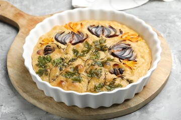 Delicious focaccia with flowers made of vegetables on grey textured table, closeup