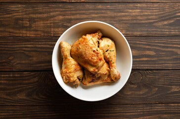 Baked chicken on wooden background, top view
