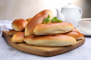 Tasty baked patties on grey textured table, closeup