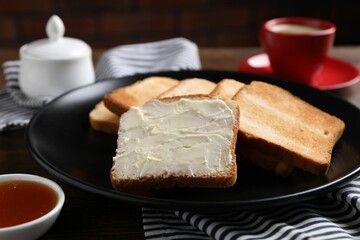 Slices of tasty toasted bread with butter and jam on table, closeup