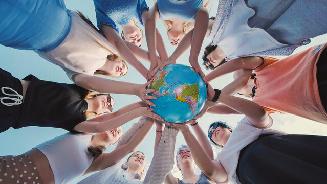 School friends holding a globe together, symbolizing environmental protection and global unity