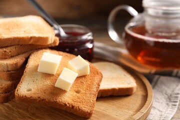 Slices of tasty toasted bread with butter on table, closeup