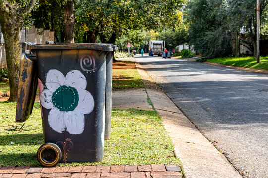 A decorated wheely garbage bin on a suburban street in South Africa ready for collection