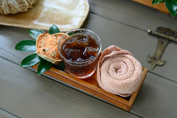 Welcome drink. Icy Bael Juice with cold towel and dry Bael desolate on wooden tray.