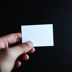 Blank Card Held in Hand on Dark Background for Business or Creative Use in Modern Settings