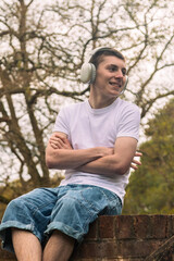 Obraz premium Teenage boy sitting on a brick wall