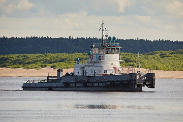 Fototapeta premium Tugboat sailing down the river, close-up