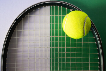 Tennis ball on racket. White and green background. Concept of sports competitions