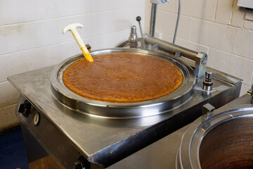 large industrial cooking pan filled with sauce in a factory location nobody.