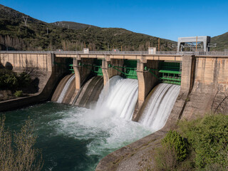 General view of the Peñarrubia reservoir dam on the Sil River, where two floodgates are open, releasing a large flow of water, forming a white stream downwards