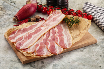 Sliced pork bacon over board