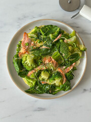 Omelette with broccoli, pies, spinach, baked trout and microgreens. Top view of the dish.