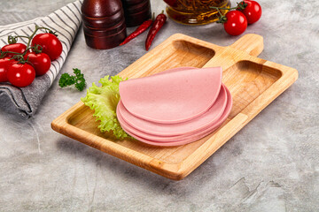 Sliced boiled sausage over board