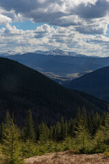 Obraz premium view from the mountain to the village in the valley at the foot of a mighty snow-capped peak, sky with clouds