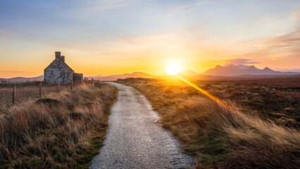 Sunrise behind the Moine House. A ruin of a stone cottage in the remote moorland in Sutherland in the far north of the Scottish Highlands.